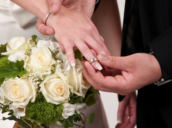 blumen und ehering auf finger