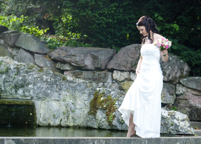 braut barfuss an einem brunnen