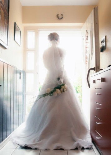 braut im kleid steht an der haustür